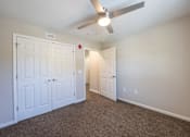 Thumbnail 42 of 52 - A room with a ceiling fan and carpeted floor.