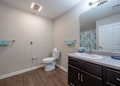 Thumbnail 48 of 52 - A white toilet sits in a bathroom next to a white sink.
