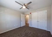 Thumbnail 41 of 52 - A room with a ceiling fan and carpeted floor.