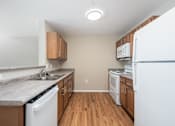 Thumbnail 27 of 58 - A kitchen with white appliances and wooden cabinets.