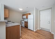 Thumbnail 33 of 58 - A kitchen with a white refrigerator and wooden cabinets.