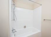 Thumbnail 34 of 58 - A white bathtub with a shower head and a faucet.