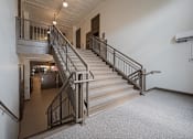 Thumbnail 47 of 58 - A staircase with a metal railing and a carpeted floor.