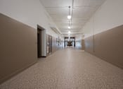 Thumbnail 49 of 58 - A long hallway with doors on both sides and a light on the ceiling.