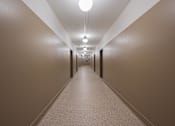 Thumbnail 40 of 58 - A long hallway with lights on the ceiling.