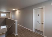 Thumbnail 19 of 58 - A room with a door labeled 305 and a staircase leading to the upper floor.