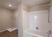 Thumbnail 17 of 58 - A white bathroom with a walk-in shower and a toilet mat on the floor.