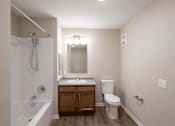 Thumbnail 18 of 58 - A small bathroom with a white tub, sink, and toilet.