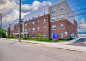 Thumbnail 6 of 64 - a large brick building with a blue sign in front of it