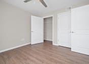 Thumbnail 37 of 64 - a bedroom with two doors and a ceiling fan