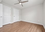 Thumbnail 39 of 64 - a bedroom with a ceiling fan and hardwood floors
