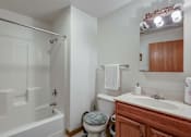Thumbnail 26 of 27 - A white bathroom with a toilet, sink, and bathtub.