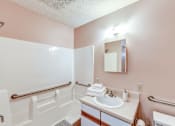 Thumbnail 26 of 26 - A bathroom with a sink, mirror, and toilet.