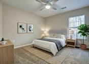 Thumbnail 35 of 35 - A bedroom with a bed, nightstand, and a ceiling fan.