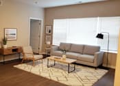 Thumbnail 18 of 19 - A living room with a grey couch, a coffee table, and a rug.