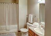 Thumbnail 28 of 29 - A white toilet sits next to a sink in a bathroom.