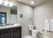 Thumbnail 28 of 28 - A bathroom with a toilet, sink, and towels.