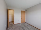 Thumbnail 42 of 59 - A room with two doors and carpeted floor.