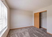 Thumbnail 55 of 59 - A room with a carpeted floor and a wooden door.