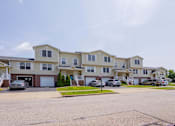 Thumbnail 53 of 59 - A row of townhouses with cars parked in front.