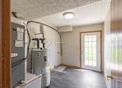Thumbnail 32 of 59 - A room with a furnace and air conditioner unit.