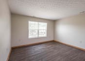 Thumbnail 36 of 59 - A room with a window and wooden flooring.
