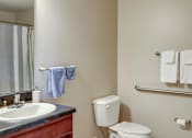 Thumbnail 40 of 42 - A bathroom with a toilet, sink, and towels.