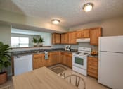Thumbnail 29 of 31 - A kitchen with wooden cabinets and white appliances.