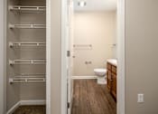 Thumbnail 12 of 16 - A white toilet is in a small bathroom with a walk-in closet.