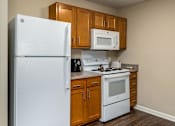 Thumbnail 14 of 41 - a small kitchen with white appliances and wooden cabinets