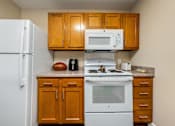 Thumbnail 7 of 41 - a kitchen with a white stove top oven next to a refrigerator