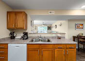 Thumbnail 15 of 41 - a kitchen with wooden cabinets and a white dishwasher