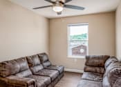 Thumbnail 28 of 41 - a living room with two couches and a ceiling fan