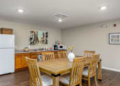 Thumbnail 33 of 41 - a dining area with a table and chairs and a kitchen in the background