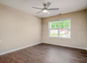 Thumbnail 10 of 36 - a bedroom with a large window and a ceiling fan