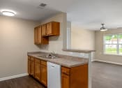 Thumbnail 19 of 36 - a kitchen with brown cabinets and a white dishwasher
