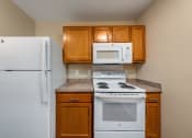 Thumbnail 20 of 36 - a kitchen with white appliances and brown cabinets