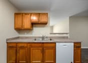 Thumbnail 21 of 36 - a kitchen with brown cabinets and a white dishwasher