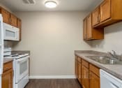 Thumbnail 15 of 36 - a kitchen with wood cabinets and white appliances