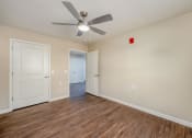 Thumbnail 16 of 36 - a bedroom with hardwood floors and a ceiling fan