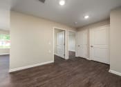 Thumbnail 29 of 36 - a bedroom with white walls and wood flooring