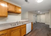 Thumbnail 24 of 36 - a kitchen with wood cabinets and a white dishwasher
