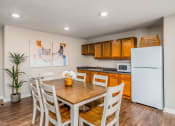 Thumbnail 31 of 36 - a kitchen with a wooden table and chairs and a white refrigerator