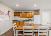 Thumbnail 33 of 36 - a kitchen with a wooden table and white chairs