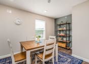 Thumbnail 35 of 36 - a dining room with a table and chairs and a bookshelf