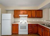 Thumbnail 15 of 16 - A kitchen with white appliances and wooden cabinets.