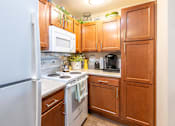 Thumbnail 13 of 55 - A kitchen with wooden cabinets and a white refrigerator.