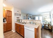 Thumbnail 14 of 55 - A kitchen with wooden cabinets and a white dishwasher.