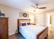 Thumbnail 18 of 55 - A bedroom with a bed, dresser, and a ceiling fan.