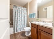 Thumbnail 19 of 55 - A bathroom with a toilet, sink, and shower curtain.